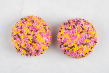 Beyaz arka plana renkli serpiştirilmiş iki taze kurabiye. Yüksek kalite fotoğraf