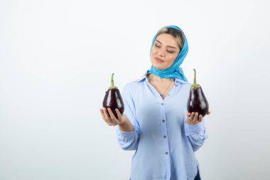 Mendilli, patlıcan tutan sarışın güzel bir kadın resmi. Yüksek kalite fotoğraf