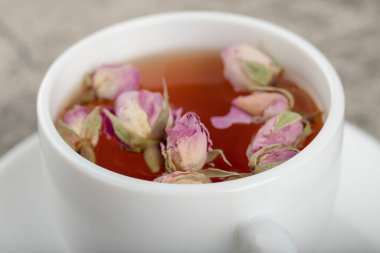 Taş yüzeyinde kurumuş güller olan bir fincan siyah çay. Yüksek kalite fotoğraf