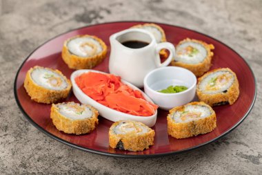 Wasabi, soya sosu ve taş bir masaya konmuş zencefil dilimli taze suşi ruloları. Yüksek kalite fotoğraf