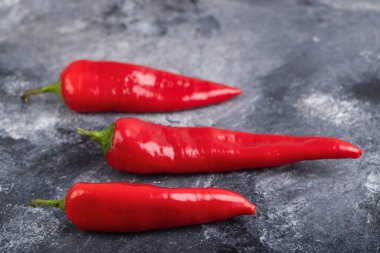 Red fresh chili peppers placed on marble surface. High quality photo