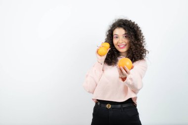 Güzel kıvırcık kız elinde taze portakal meyveleri tutuyor. Yüksek kalite fotoğraf
