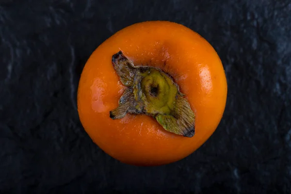 Single Fresh Fuyu Persimmon Placed Black Surface 고품질 — 스톡 사진