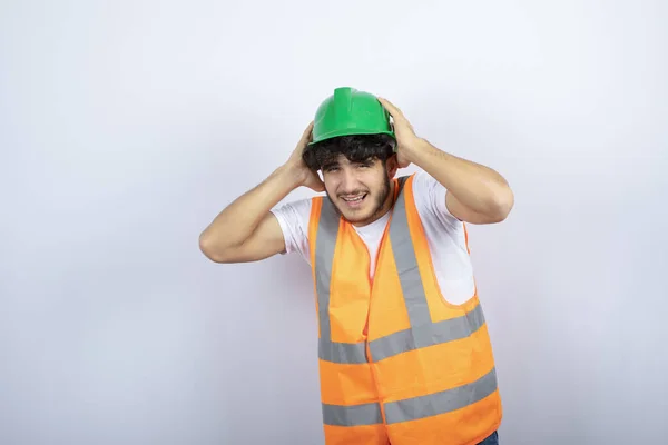 Joven Trabajador Construcción Hardhat Verde Sosteniendo Sus Orejas Foto Alta — Foto de Stock