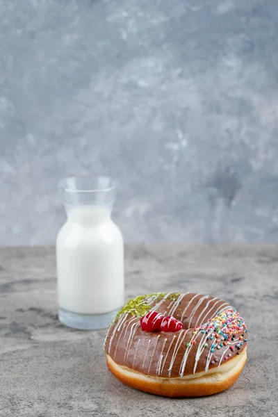 Çikolatalı çörek ve taş yüzeyde bir bardak taze sütle süslenmiş. Yüksek kalite fotoğraf