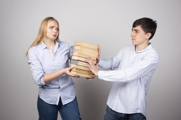 Junger Mann Überreicht Seiner Partnerin Ein Buch Auf Grauem Hintergrund — Stockfoto