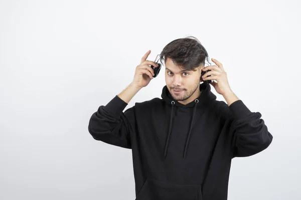 Siyah Kapüşonlu Yakışıklı Genç Adam Büyük Kablosuz Müzik Kulaklıkları Takıyor — Stok fotoğraf