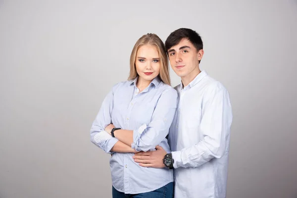 Casal Jovem Olhando Para Câmera Contra Parede Cinza Foto Alta — Fotografia de Stock