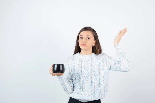 Młoda Kobieta Trzyma Filiżankę Gorącej Kawy Nad Białą Ścianą Wysokiej — Zdjęcie stockowe