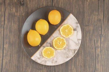 Tabaktaki taze limonların ahşap zemin üzerindeki görüntüsü. Yüksek kalite fotoğraf