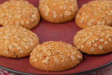 Ahşap zemin üzerinde kırmızı tabak lezzetli yulaflı kurabiyeler. Yüksek kalite fotoğraf