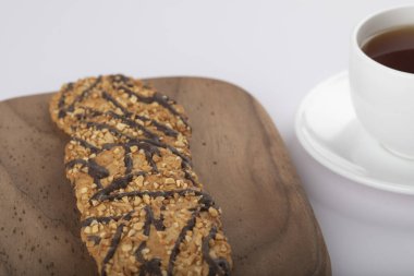 Beyaz masaya çok tahıllı kurabiyeler konmuş beyaz çay fincanı. Yüksek kalite fotoğraf