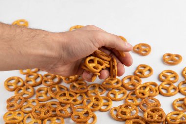 Beyaz arka planda bir avuç tuzlu kraker tutan bir erkek. Yüksek kalite fotoğraf