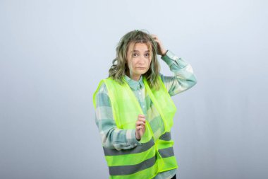 Beyaz duvarın üzerinde duran ve poz veren üniformalı kadın mimarın portresi. Yüksek kalite fotoğraf