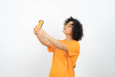 Akıllı telefonlu genç kadın beyaz arka planda poz veriyor 