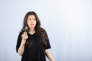 Beyaz arka planda fırçası olan genç ve güzel bir model. Yüksek kalite fotoğraf