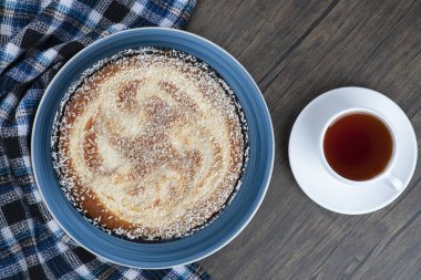 Tahta masaya bir fincan siyah çay ile bir tabak lezzetli turta. Yüksek kalite fotoğraf