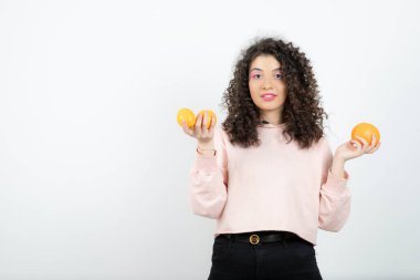 Güzel kıvırcık kız elinde taze portakal meyveleri tutuyor. Yüksek kalite fotoğraf