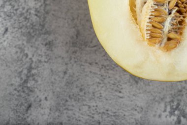 Taş zemine yarım dilimlenmiş sarı kavun yerleştirilmiş. Yüksek kalite fotoğraf