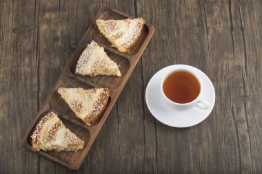 Hindistan cevizi dilimli tatlı dilimleri ve ahşap masaya konmuş bir fincan çay. Yüksek kalite fotoğraf