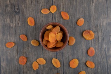 Ahşap bir masada sağlıklı kurutulmuş kayısı meyveleriyle dolu bir kase. Yüksek kalite fotoğraf