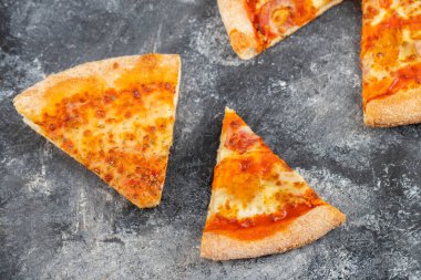 Taş zemine yerleştirilmiş lezzetli peynirli pizza dilimleri. Yüksek kalite fotoğraf