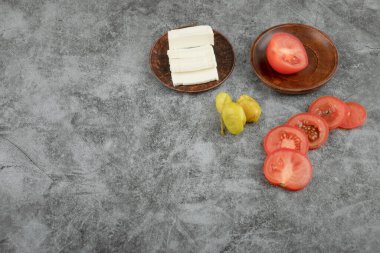 Dilimlenmiş beyaz peynir ve taş zeminde taze domatesler. Yüksek kalite fotoğraf