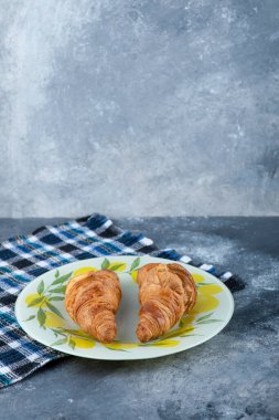 Taze ve lezzetli kruvasanlar taş masaya konmuş. Yüksek kalite fotoğraf
