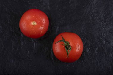 Siyah arka plana yerleştirilmiş kırmızı taze domatesler. Yüksek kalite fotoğraf