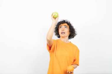 Meyveli genç kadın beyaz arka planda poz veriyor