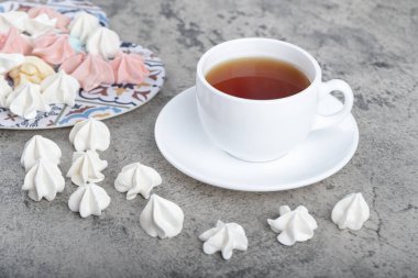 Renkli tatlı kremalı şekerler ve arka planda bir fincan çay. Yüksek kalite fotoğraf