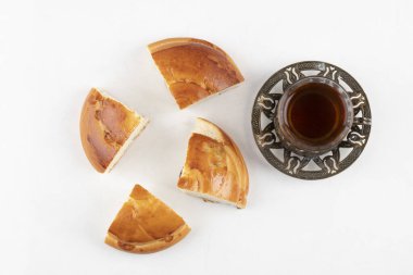 Dilimlenmiş taze hamur işi ve beyaz arka planda bir bardak çay. Yüksek kalite fotoğraf