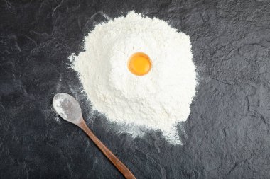 Siyah yüzeyde çiğ yumurta sarısı ve un ile ekmek hazırlığı. Yüksek kalite fotoğraf