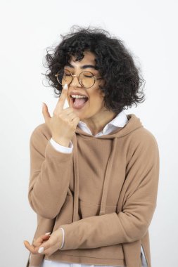 Beyaz arka planda poz veren genç bir kadın