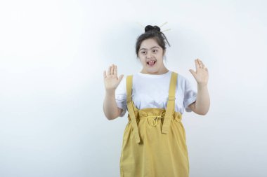 Beyaz duvara karşı duran ve poz veren genç, güzel bir kız. Yüksek kalite fotoğraf