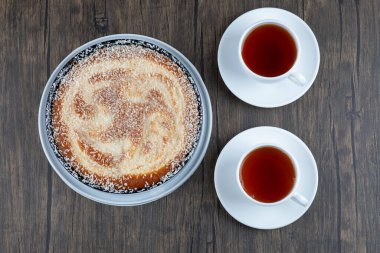 Tahta bir masaya siyah çay konmuş bir tabak lezzetli turta. Yüksek kalite fotoğraf