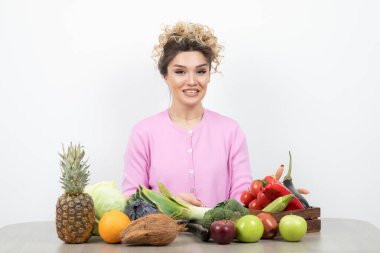 Masasında oturan pembe bluzlu, kıllı hindistan cevizli güzel kıvırcık kadın. Yüksek kalite fotoğraf