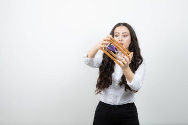 Uzun saçlı güzel bir kız kum saatini tam saati kontrol etmek için kullanıyor. Yüksek kalite fotoğraf