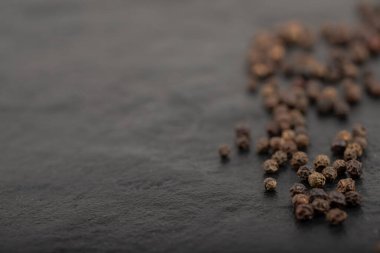 Siyah yüzeye dağılmış organik siyah karabiber yığını. Yüksek kalite fotoğraf