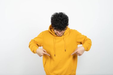 Genç, esmer bir adamın kapüşonlusunu gösterirken çekilmiş fotoğrafı. Yüksek kalite fotoğraf