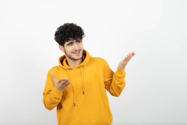 Sarı kapüşonlu, poz veren esmer bir adamın fotoğrafı. 