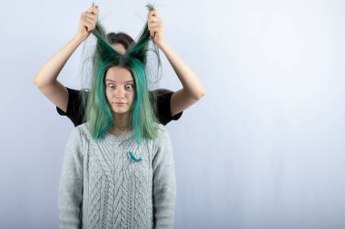 Genç bir kadın beyaz arka planda arkadaşıyla oynuyor. Yüksek kalite fotoğraf