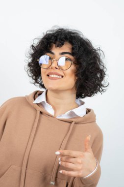 Beyaz arka planda poz veren genç bir kadın 