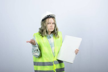 Elinde boş tuval tutan ve düşünen güzel kadın endüstriyel işçinin fotoğrafı. Yüksek kalite fotoğraf
