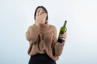 Kokusu yüzünden burnunu tutan şarap şişesiyle genç bir kadının portresi. Yüksek kalite fotoğraf