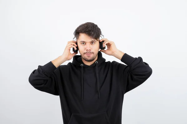 Siyah Kapüşonlu Yakışıklı Genç Adam Büyük Kablosuz Müzik Kulaklıkları Takıyor — Stok fotoğraf