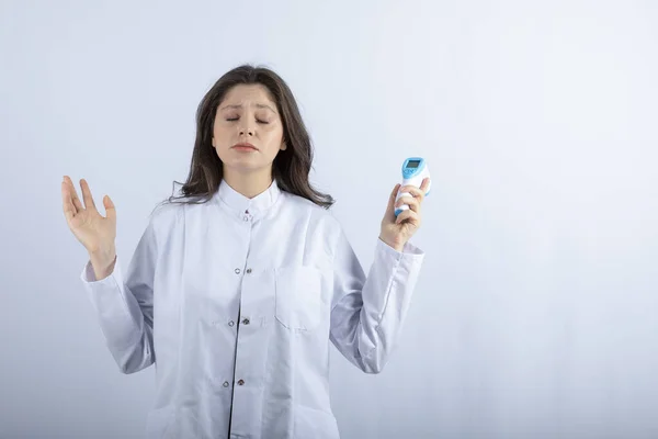 Foto Jovem Médico Segurando Termômetro Fundo Branco Foto Alta Qualidade — Fotografia de Stock