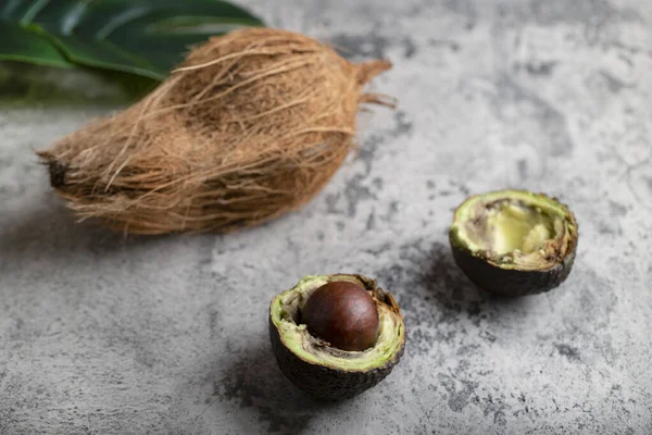 Kokosfrucht Und Scheiben Geschnittene Avocado Auf Steingrund Gelegt Hochwertiges Foto — Stockfoto
