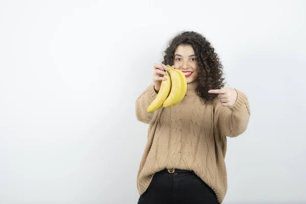 Zdjęcie Kręconej Młodej Kobiety Trzymającej Banany Białym Wysokiej Jakości Zdjęcie — Zdjęcie stockowe