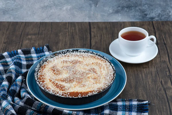 Tahta masaya bir fincan siyah çay ile bir tabak lezzetli turta. Yüksek kalite fotoğraf